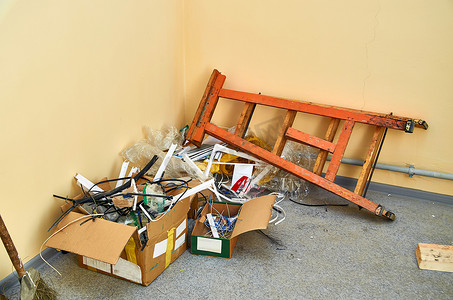 电线摄影照片_箱子里有一箱建筑碎片在房间的角落里。从电器、电线和电缆通道进行的各种包装。垃圾。家庭维修。清洗.