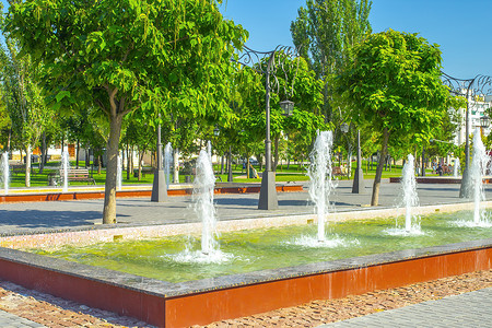 夏日公园里喷出喷泉.用水花和水滴浇灌泉水。喷泉中的水柱.