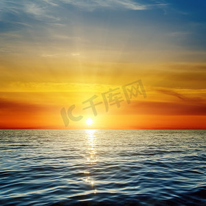 Orange solnedgång över mörka blå havet橘黄色的夕阳，在暗蓝色的大海