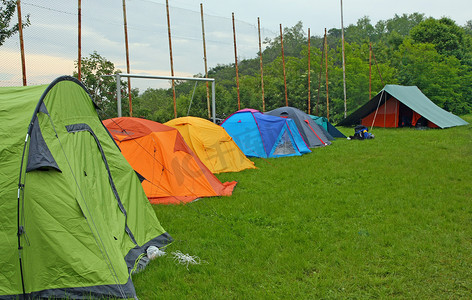 与帐篷童军露营者在一片草甸露营