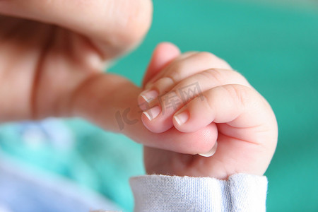 夹紧摄影照片_新出生的婴儿手母亲手指夹紧