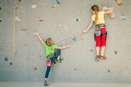 壁摄影照片_攀爬岩壁的两个小女孩