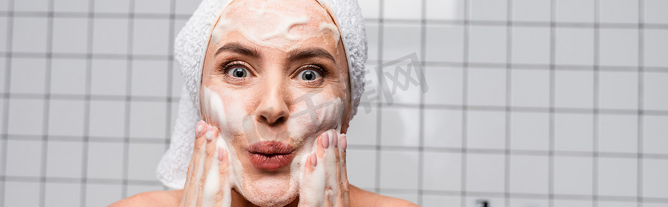 令人惊讶的摄影照片_令人惊讶的女人在浴室使用泡沫清洁剂，横幅