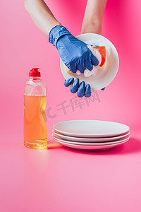 橡胶手套洗涤板、粉红色背景的女性清洁器裁剪图像 