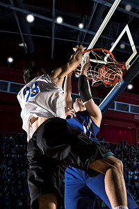 行动在健身房中的两个篮球运动员。