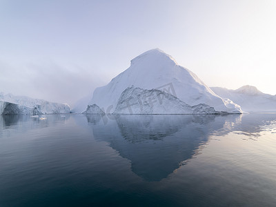 冰山之下摄影照片_北极冰山格陵兰岛北极海中。你可以很容易看到那冰山水面上和水面下。有时令人难以置信的一座冰山的 90%是在水之下