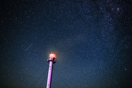 灯塔的剪影对星空的背景.