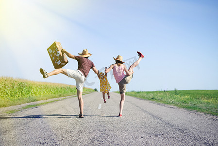 Happy family jumping and having fun on road in summer