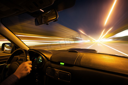 城市道路汽车摄影照片_在城市道路上的汽车速度晚上驱动器