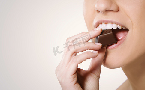 吃巧克力摄影照片_吃巧克力的女人
