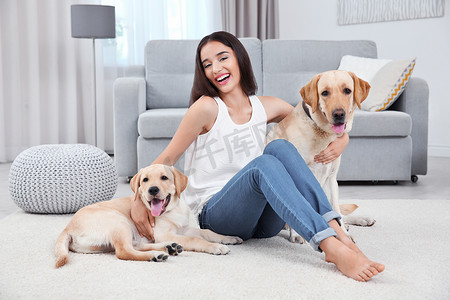 年轻女子和黄色猎犬在家休息