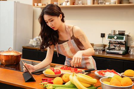 中国菜摄影照片_青年女人在家做饭