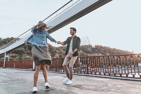 这座桥摄影照片_时尚的年轻夫妇，在这座桥上跳舞