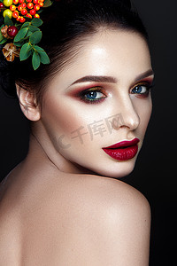 黑发模特摄影照片_年轻的黑发模特的肖像与时尚红唇妆和花圈的叶子和浆果 