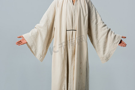 裁剪视图的人在耶稣长袍与伸出的手孤立在灰色 