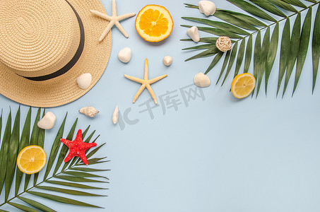 平坦的夏季度假边框.棕榈叶，水果和贝壳，草帽蓝色背景。中间的复制空间