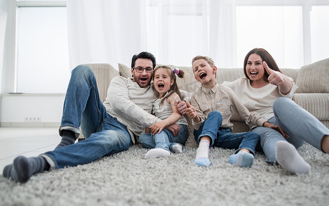 快乐的家庭坐在客厅的地毯上