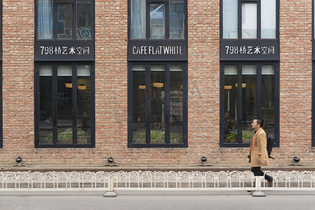 在北京的798艺术区, 男士步行路过咖啡厅