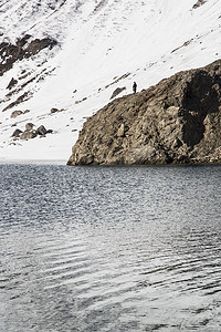 一名男子站在意大利皮埃蒙特的山谷的湖旁