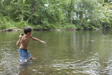 美国北卡罗来纳州坎顿市十几岁的男孩在河里撇石