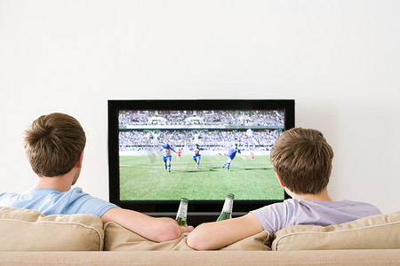 两个年轻人在电视上看足球比赛
