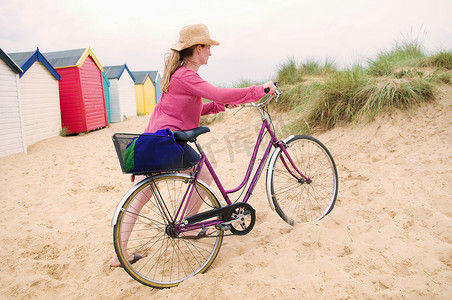 妇女推着自行车越过海滩