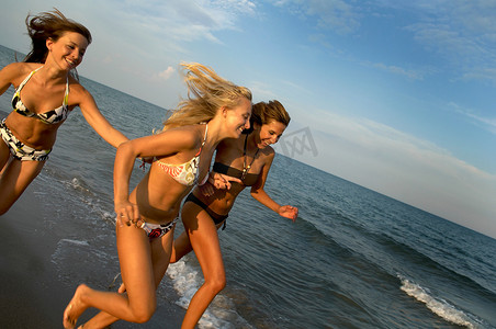 十分之三摄影照片_十几岁的女孩在海滩上奔跑
