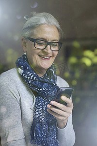 成熟的女性对智能手机上的信息微笑