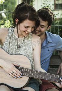公园里一对年轻夫妇在弹吉他小夜曲