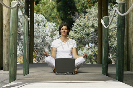 坐在电脑前做瑜伽的女人