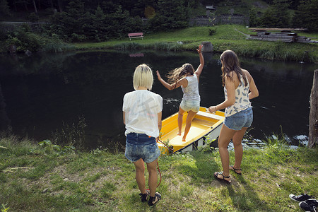 三个成年女性朋友跳上了奥地利蒂罗尔萨特尔贝勒姆湖上的赛艇