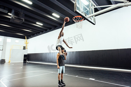 壁球室摄影照片_男子篮球运动员在篮球篮筐中肩负投球