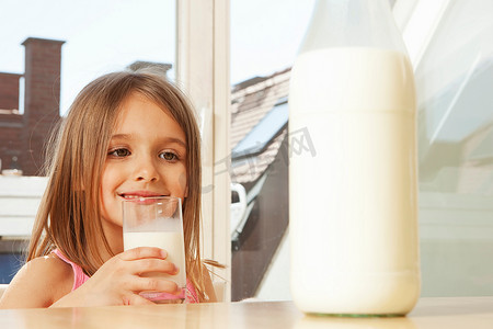 挤奶方式摄影照片_喝牛奶的小女孩