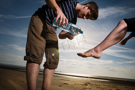 男人在海滩上给女人洗脚