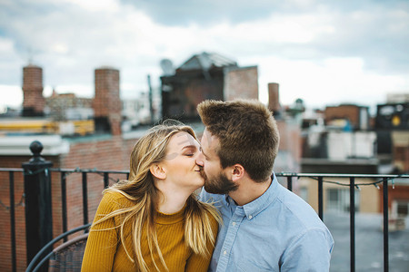浪漫的年轻情侣在城市屋顶露台接吻