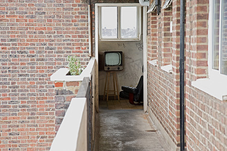 从公寓阳台上可以看到复古电视和扶手椅
