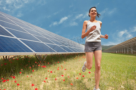 技术产业摄影照片_一名女子沿着太阳能电池板慢跑