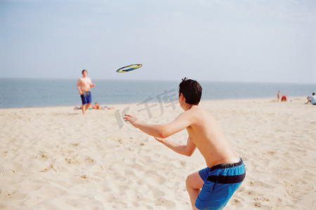 男孩们在海滩上玩飞盘