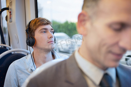 火车上听耳机的年轻人