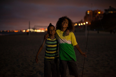 夜间钓鱼摄影照片_美国加利福尼亚州亨廷顿海滩夜间海滩上的兄弟们