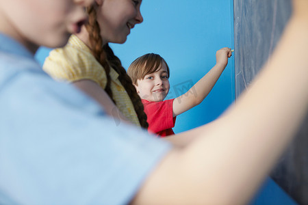孩子们在黑板上写字蓝色背景