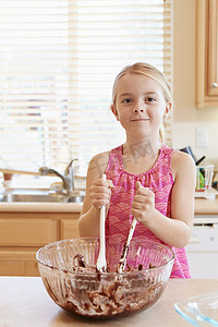 搅拌碗摄影照片_女孩在搅拌碗里融化巧克力