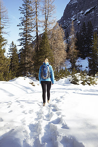 年轻女子在雪山中徒步旅行的后景奥地利