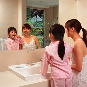 卫生间浴室镜摄影照片_母亲和女儿刷牙