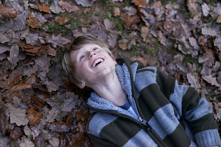 男孩仰卧在森林地面上