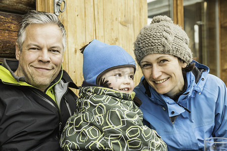 母亲父亲和儿子的肖像穿着滑雪服微笑着