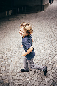 男孩在鹅卵石上跑步的高角侧视微笑布卢登茨奥地利