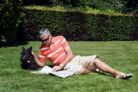 阅读之门摄影照片_成熟的男人躺在草地上看书
