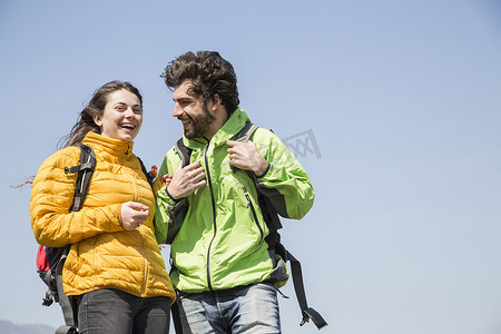一对远足夫妇在蓝天的映衬下笑了起来