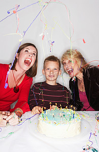 动物生日摄影照片_拿着生日蛋糕的女人和男孩